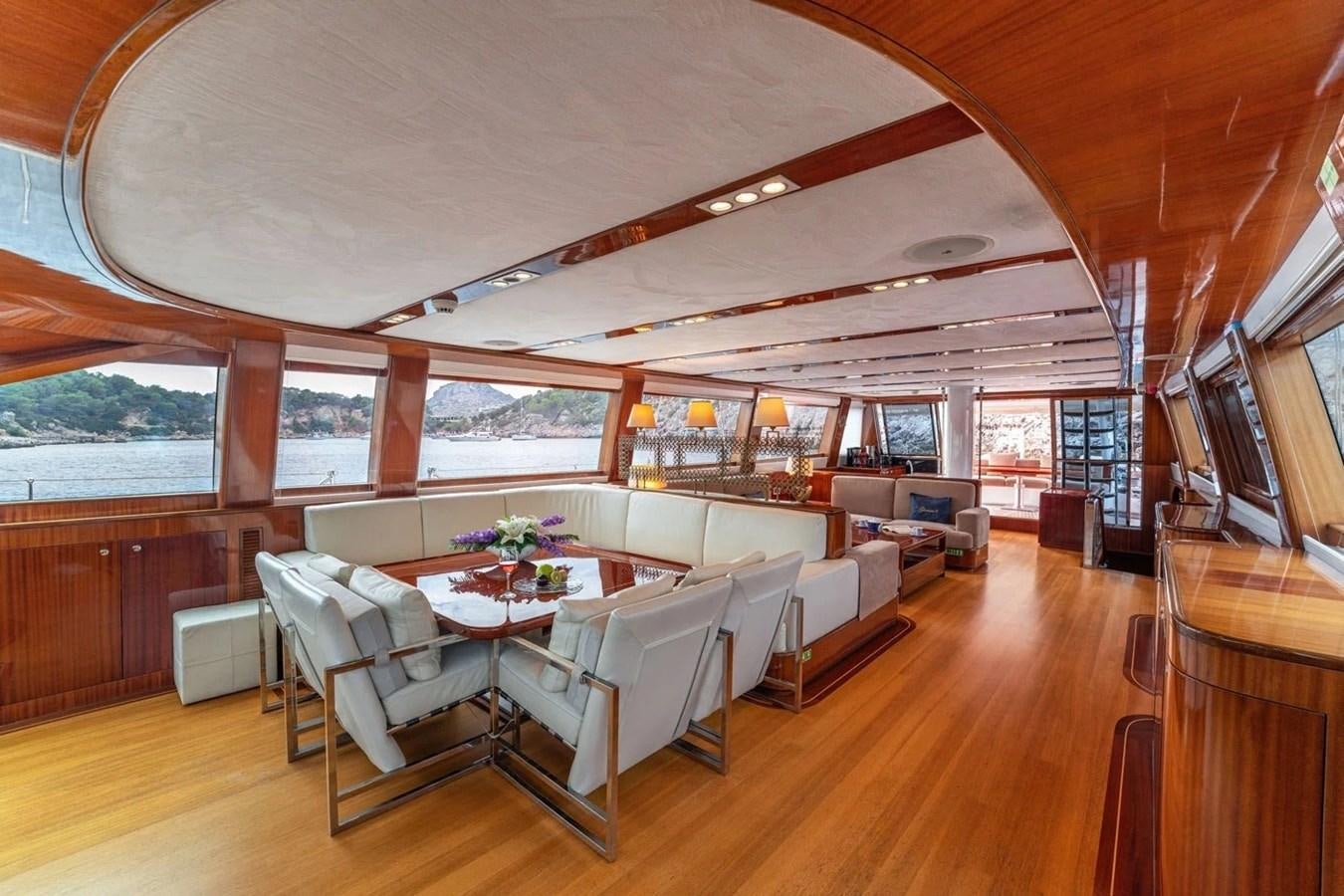 a large living room with a large table and chairs aboard CUSTOM MOTORSAILOR Yacht for Sale