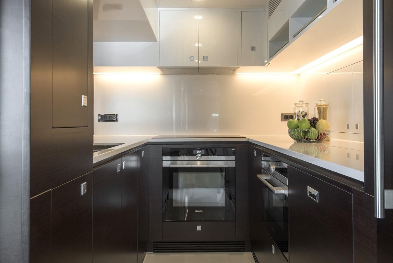 a kitchen with black appliances aboard HORIZON Yacht for Sale