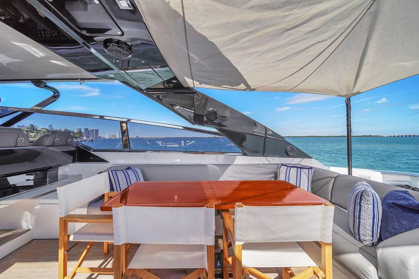 a boat with a table and chairs on the deck aboard RIVA 76' BAHAMAS Yacht for Sale