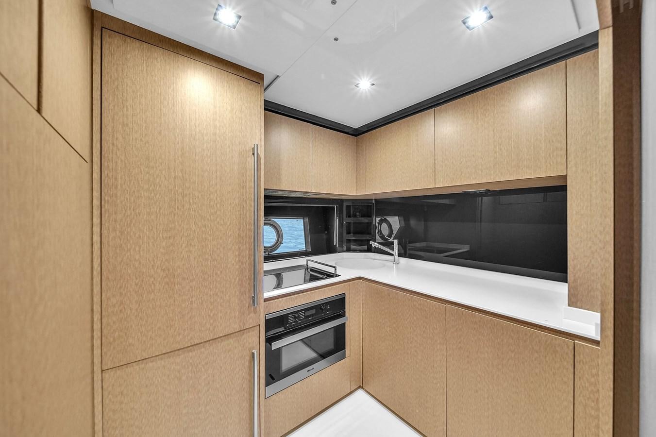 a kitchen with wooden cabinets aboard RIVA 76' BAHAMAS Yacht for Sale