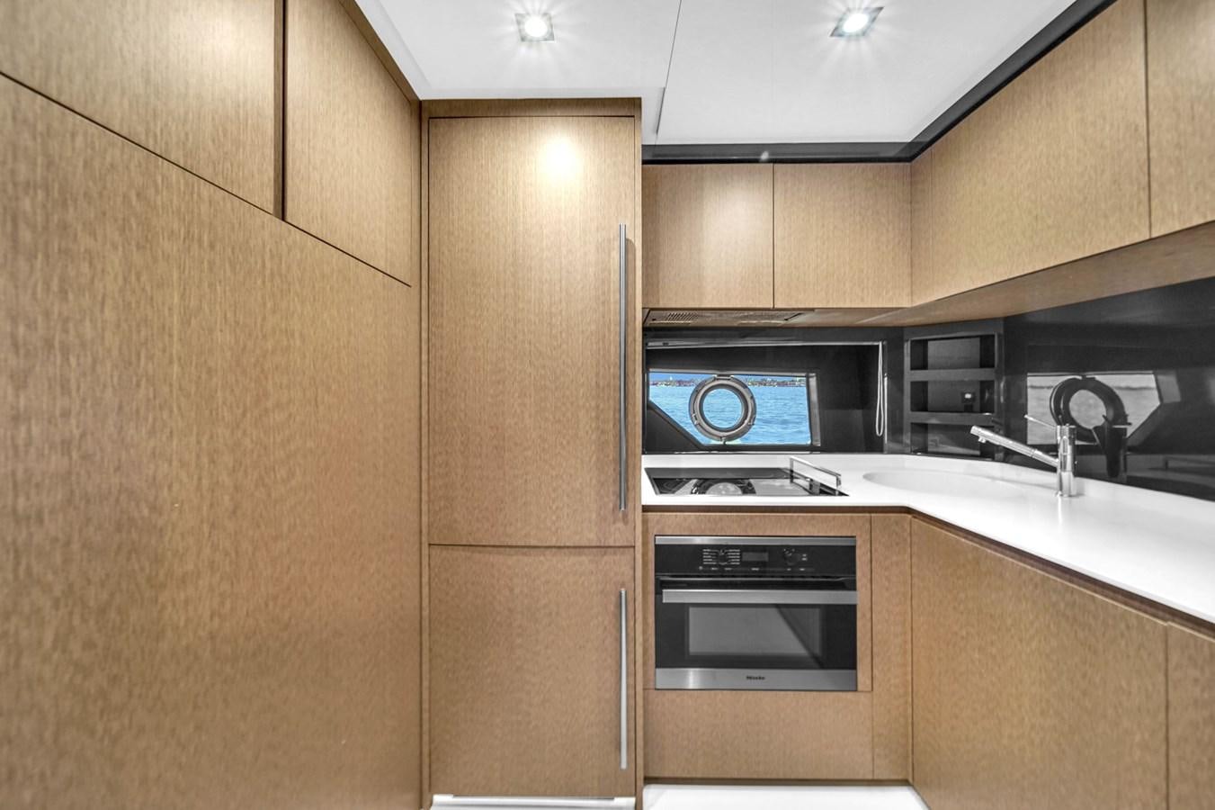 a kitchen with wooden cabinets aboard RIVA 76' BAHAMAS Yacht for Sale
