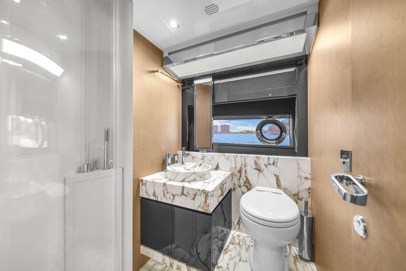 a bathroom with a sink toilet and a mirror aboard RIVA 76' BAHAMAS Yacht for Sale