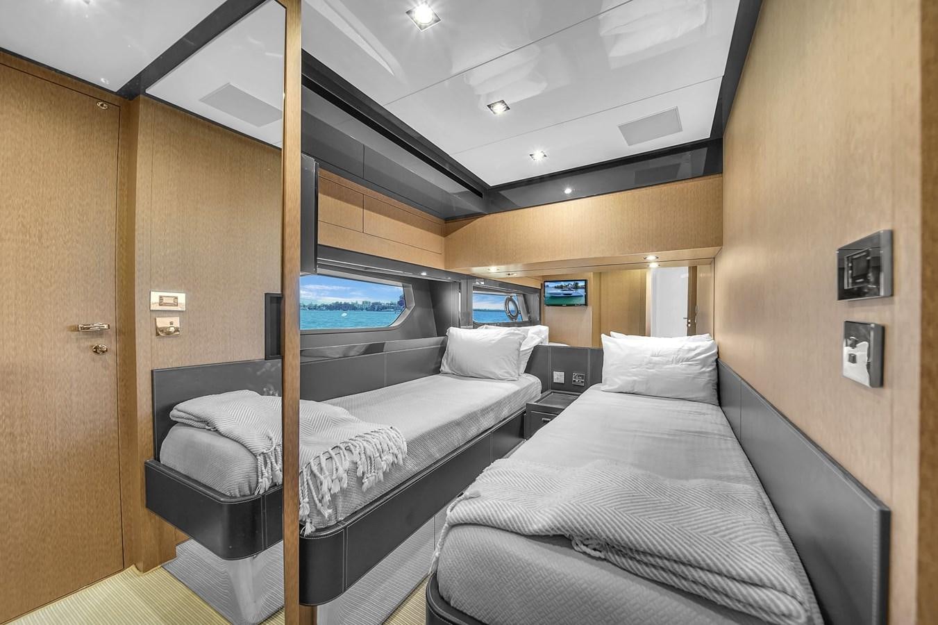a room with a bed and a television aboard RIVA 76' BAHAMAS Yacht for Sale
