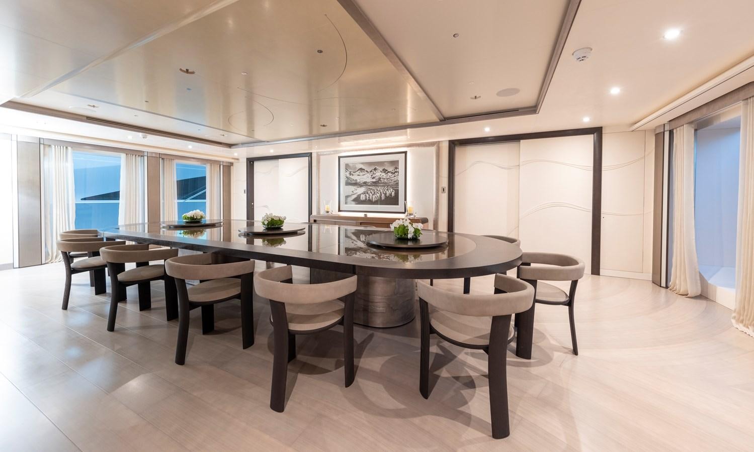 a large room with a table and chairs aboard LUNA Yacht for Sale