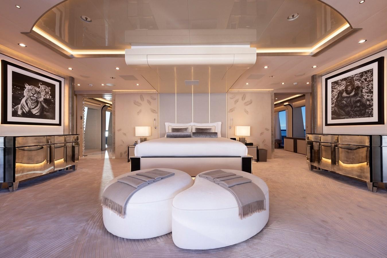 a large room with a large white bed and a large mirror aboard LUNA Yacht for Sale