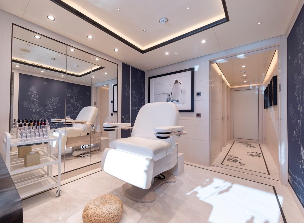 a room with a white chair and a table and a white chair aboard LUNA Yacht for Sale