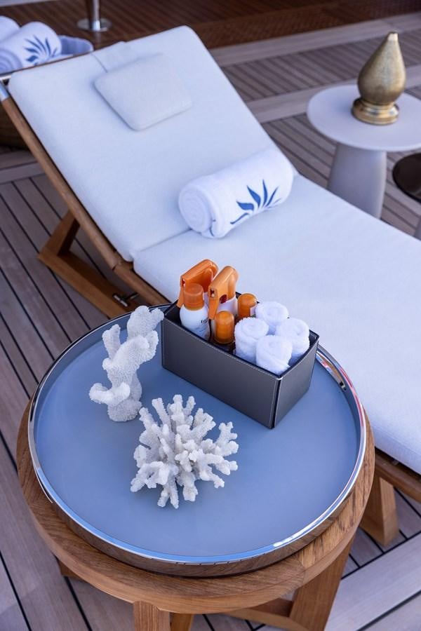 a white cake with white frosting and white flowers on a white table aboard LUNA Yacht for Sale