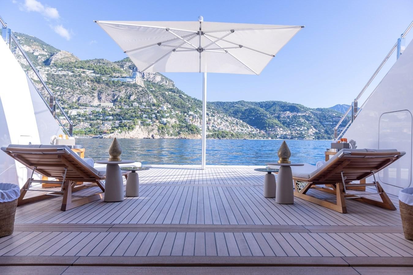 a deck with a white umbrella aboard LUNA Yacht for Sale