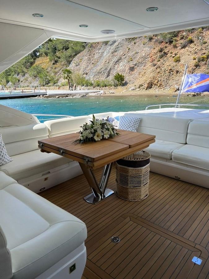 a table and chairs on a deck overlooking a body of water aboard SUNSEEKER 75 YACHT Yacht for Sale