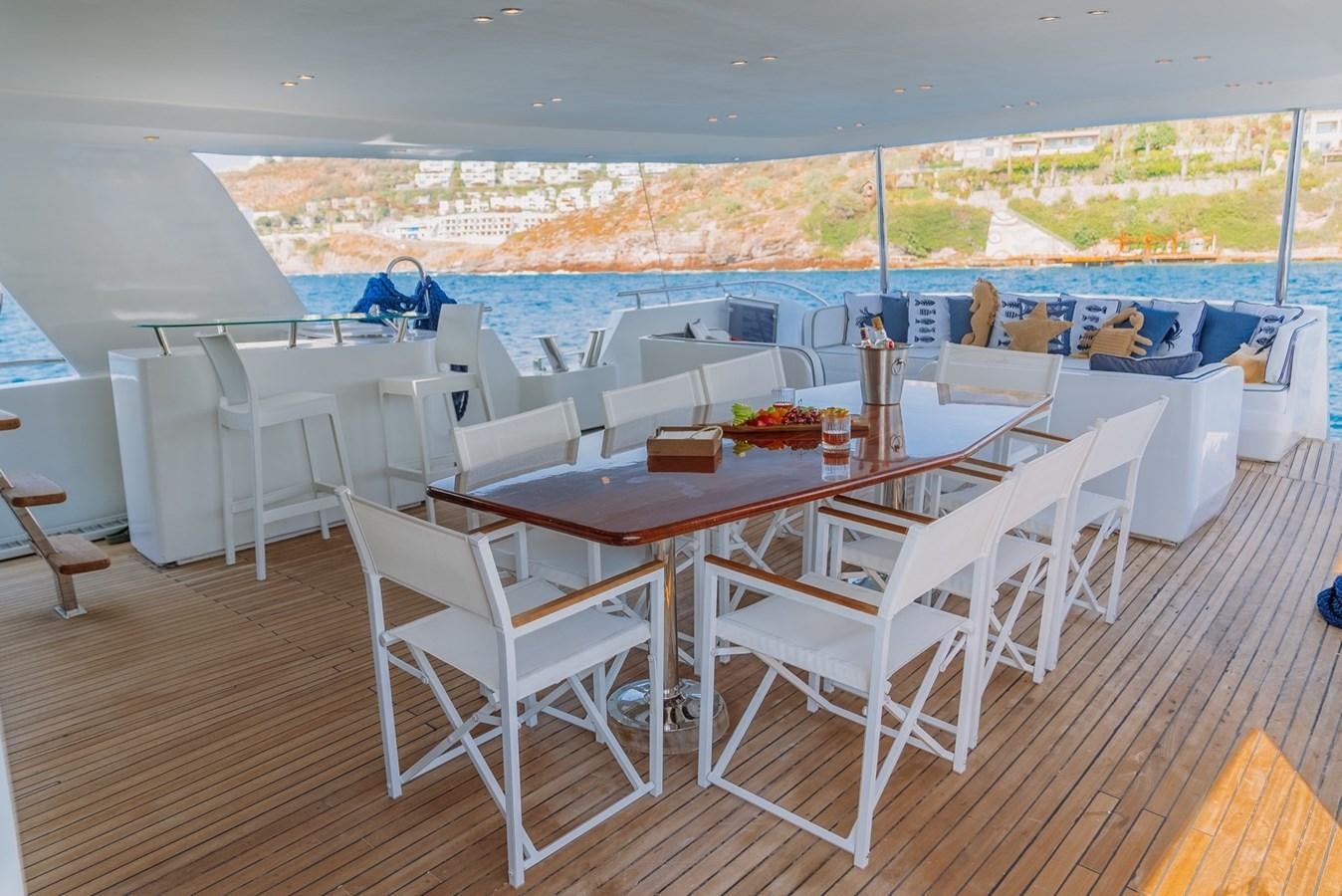 a table and chairs on a deck aboard CUSTOM MADE MOTORSAILER Yacht for Sale
