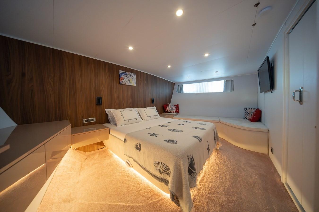 a room with a bed and a tv on the wall aboard CUSTOM MADE MOTORSAILER Yacht for Sale