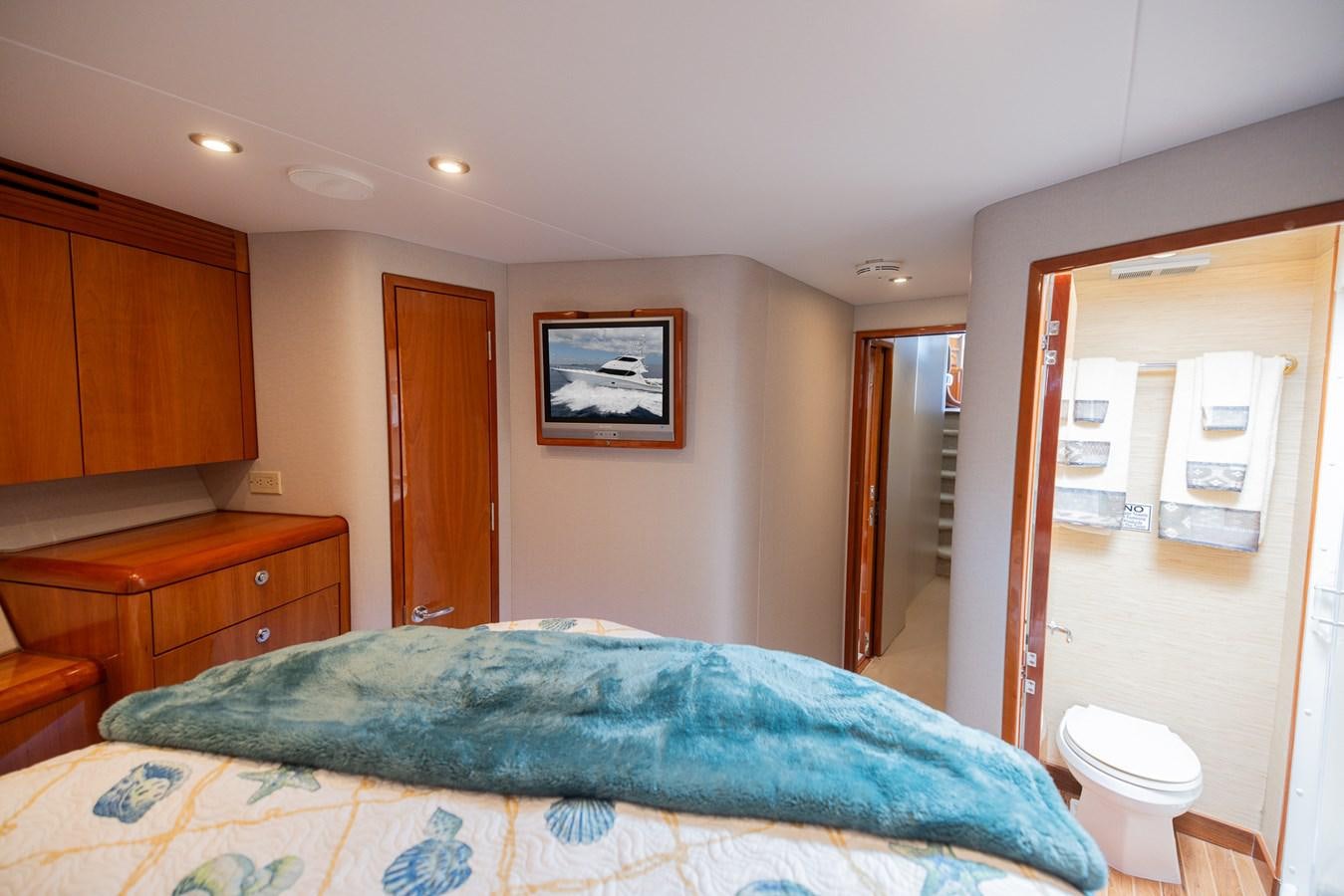 a bedroom with a bed and a dresser aboard TEMPTATION Yacht for Sale