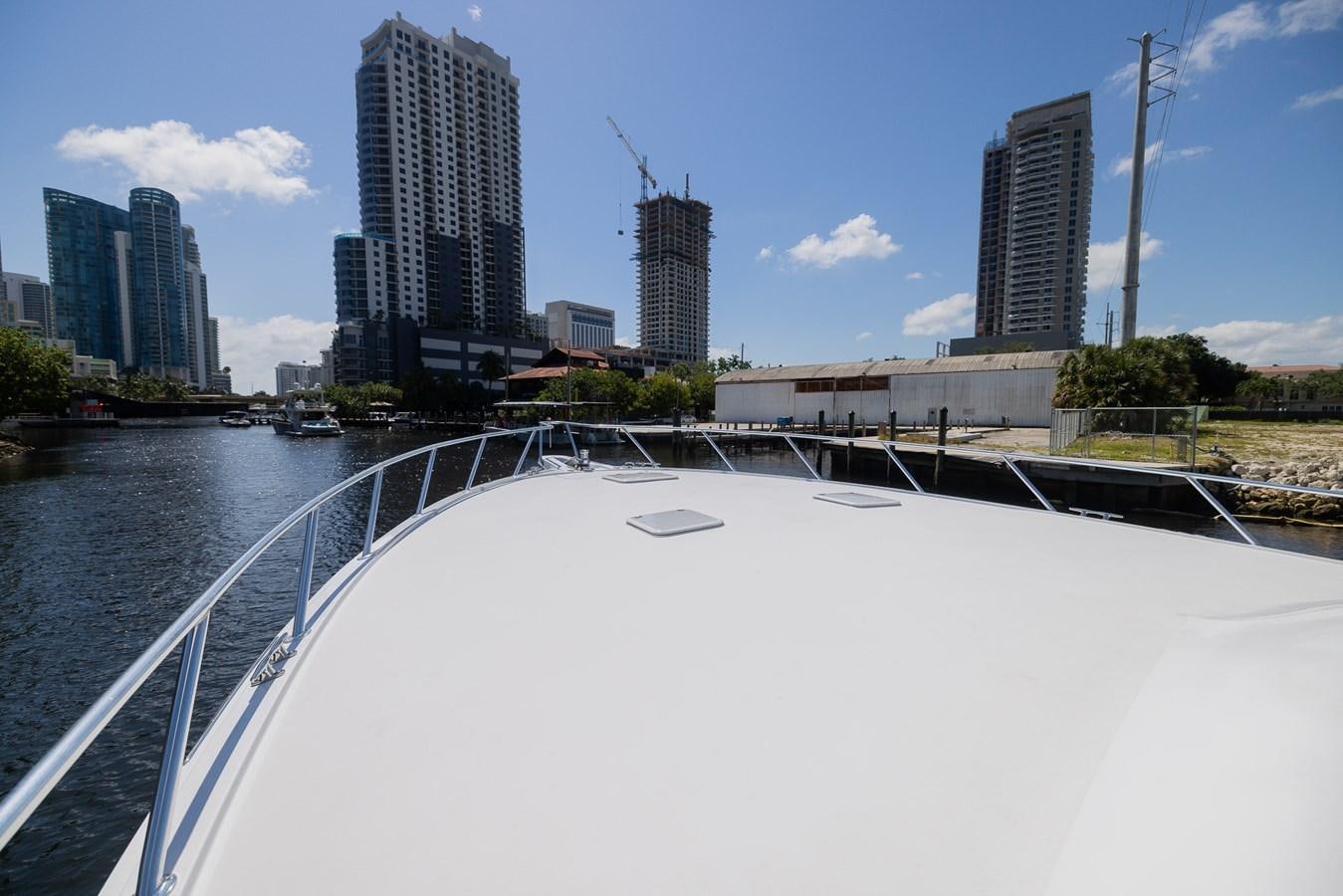a large pool with a city in the background aboard TEMPTATION Yacht for Sale