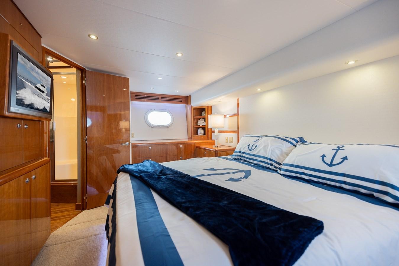 a bedroom with a bed and a television aboard TEMPTATION Yacht for Sale