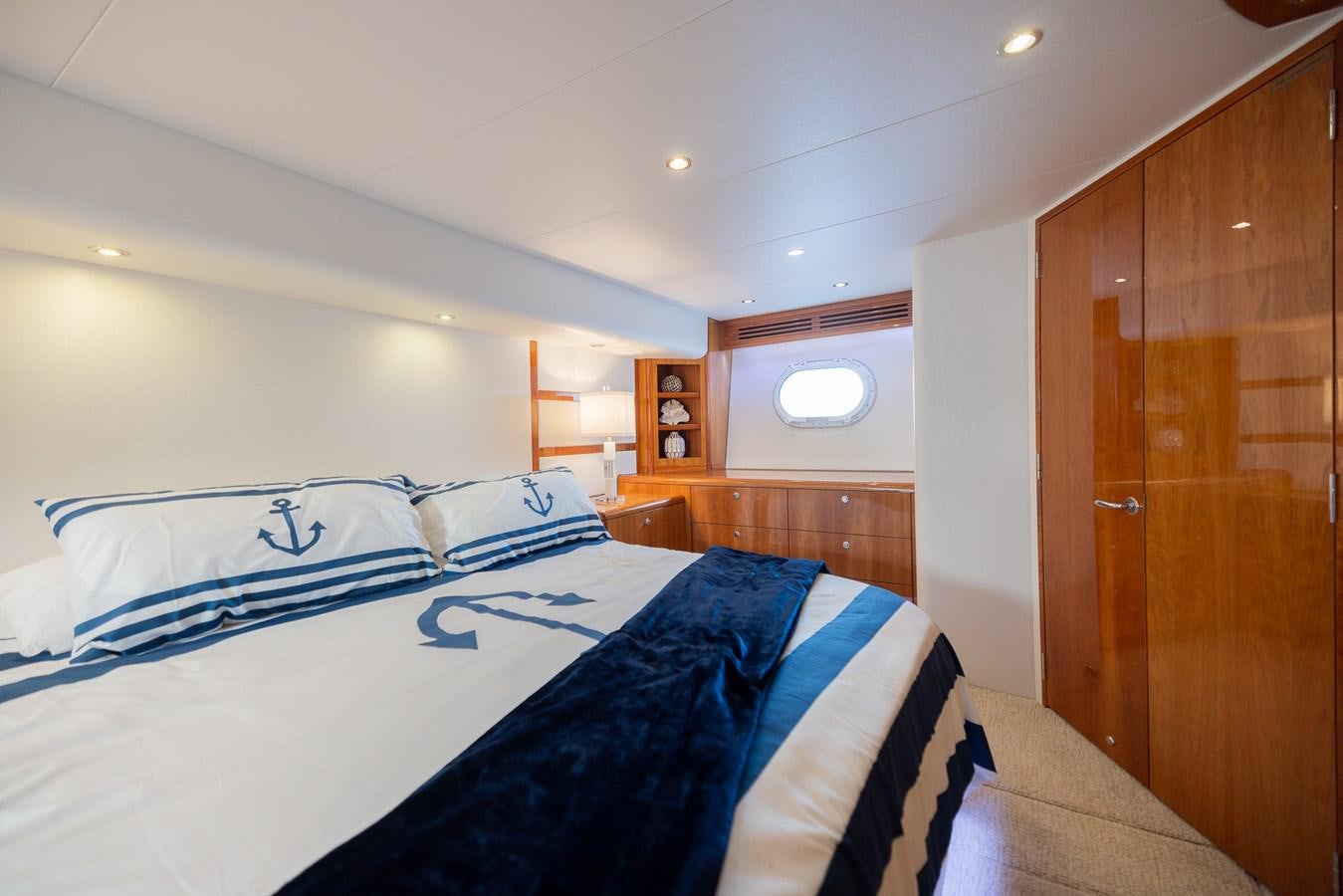 a bedroom with a bed and a closet aboard TEMPTATION Yacht for Sale