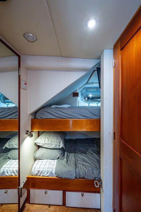 a bunk bed with a mirror above it aboard WIRE WE HERE Yacht for Sale