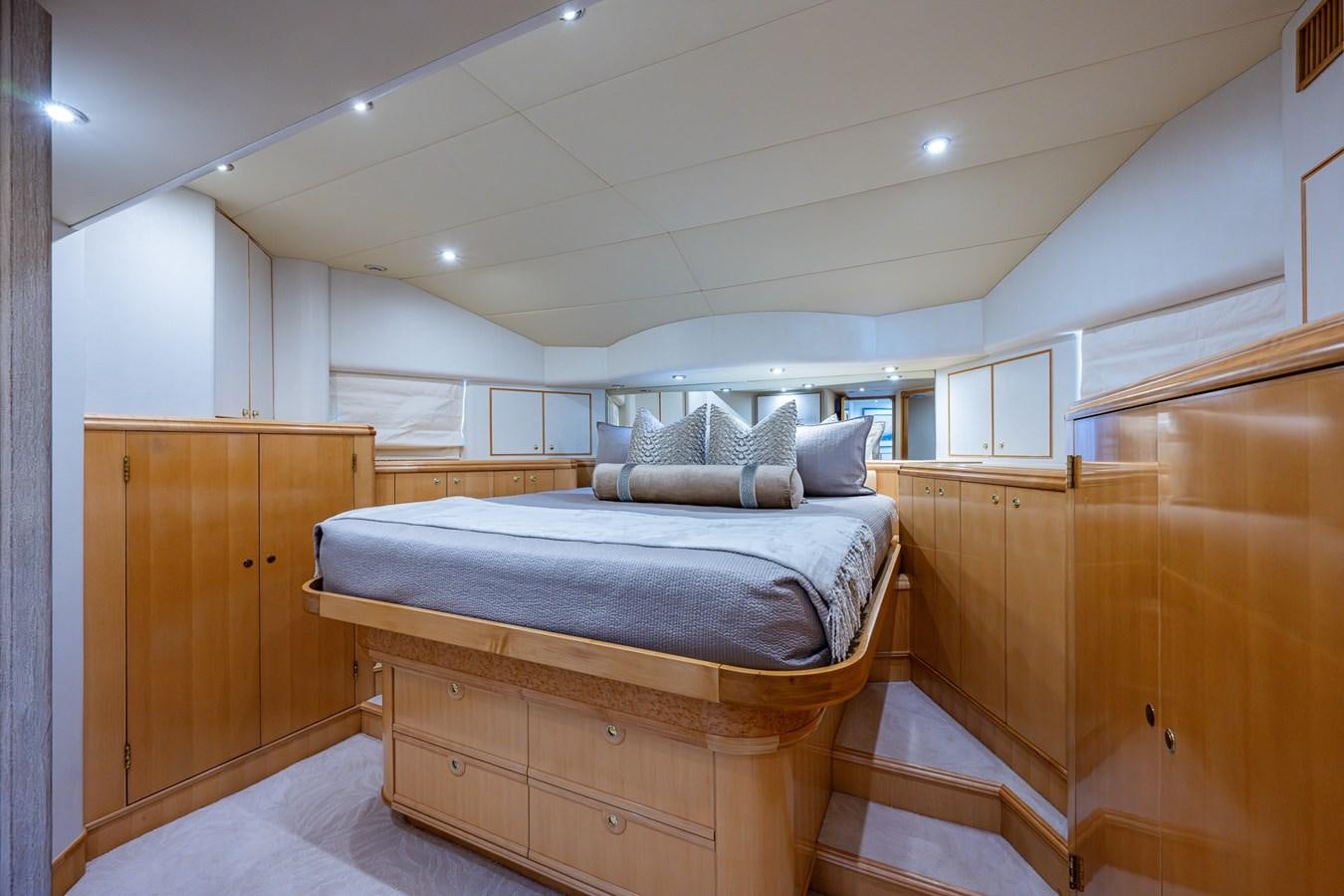 a bedroom with a bed and a wood cabinet aboard WIRE WE HERE Yacht for Sale