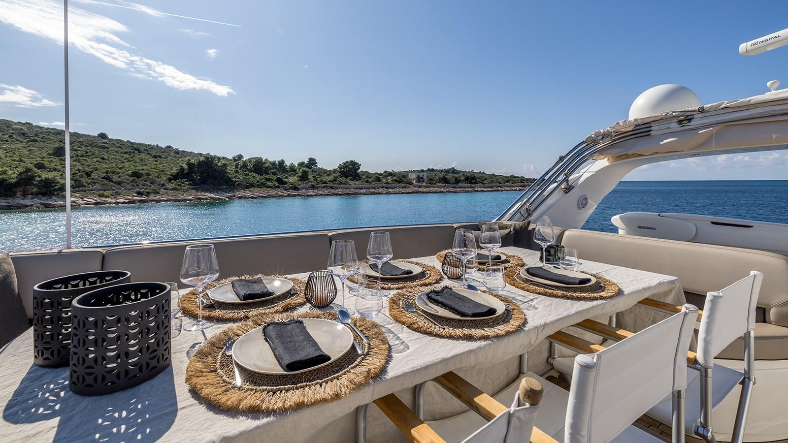 a table with plates and a hat on it aboard SEA DREAM II Yacht for Sale