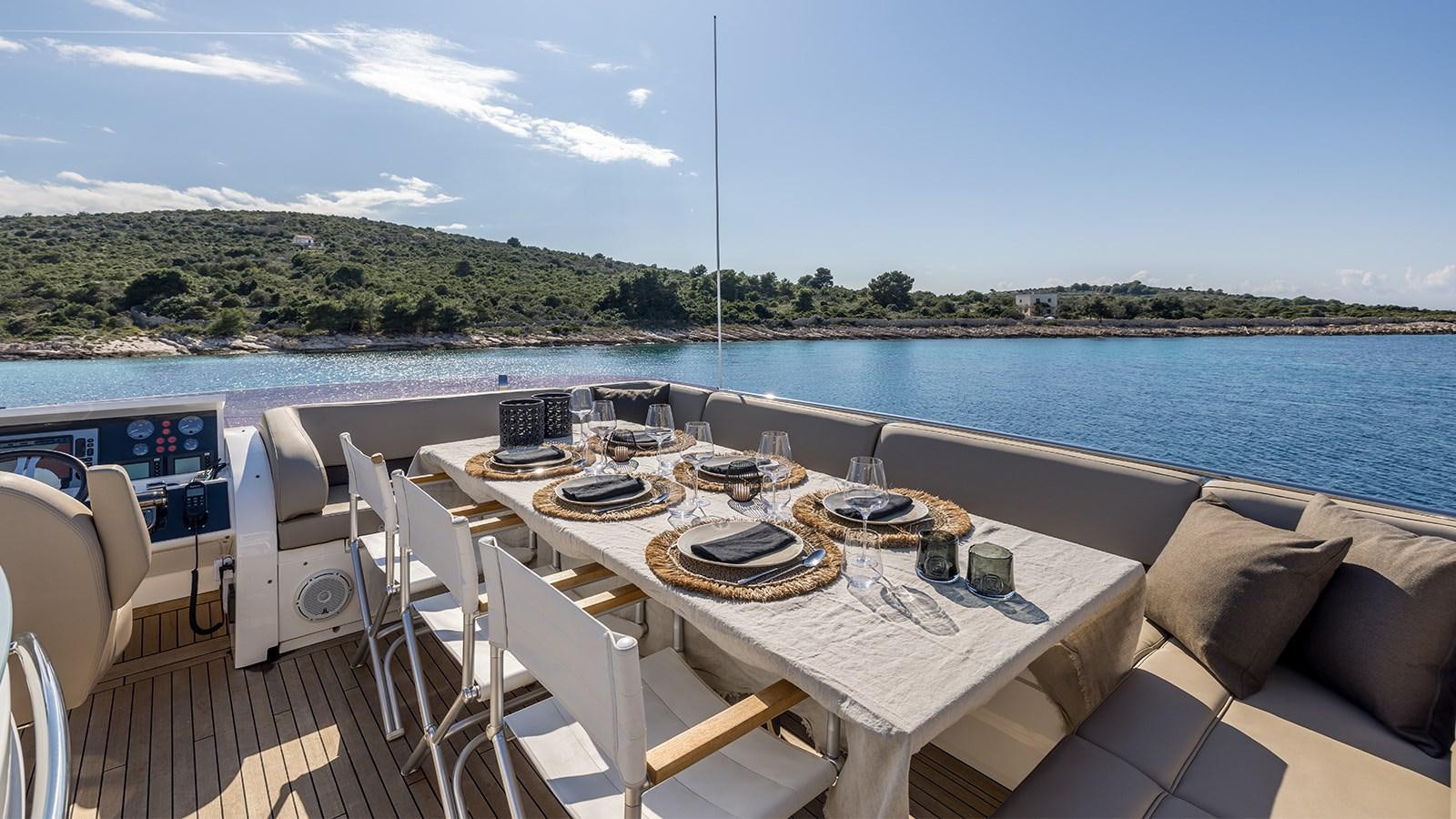 a table set for a meal on a deck overlooking a large body of water aboard SEA DREAM II Yacht for Sale