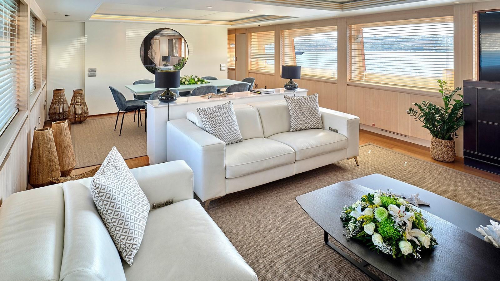 a living room with a white couch and a table with flowers aboard WHITE KNIGHT Yacht for Sale