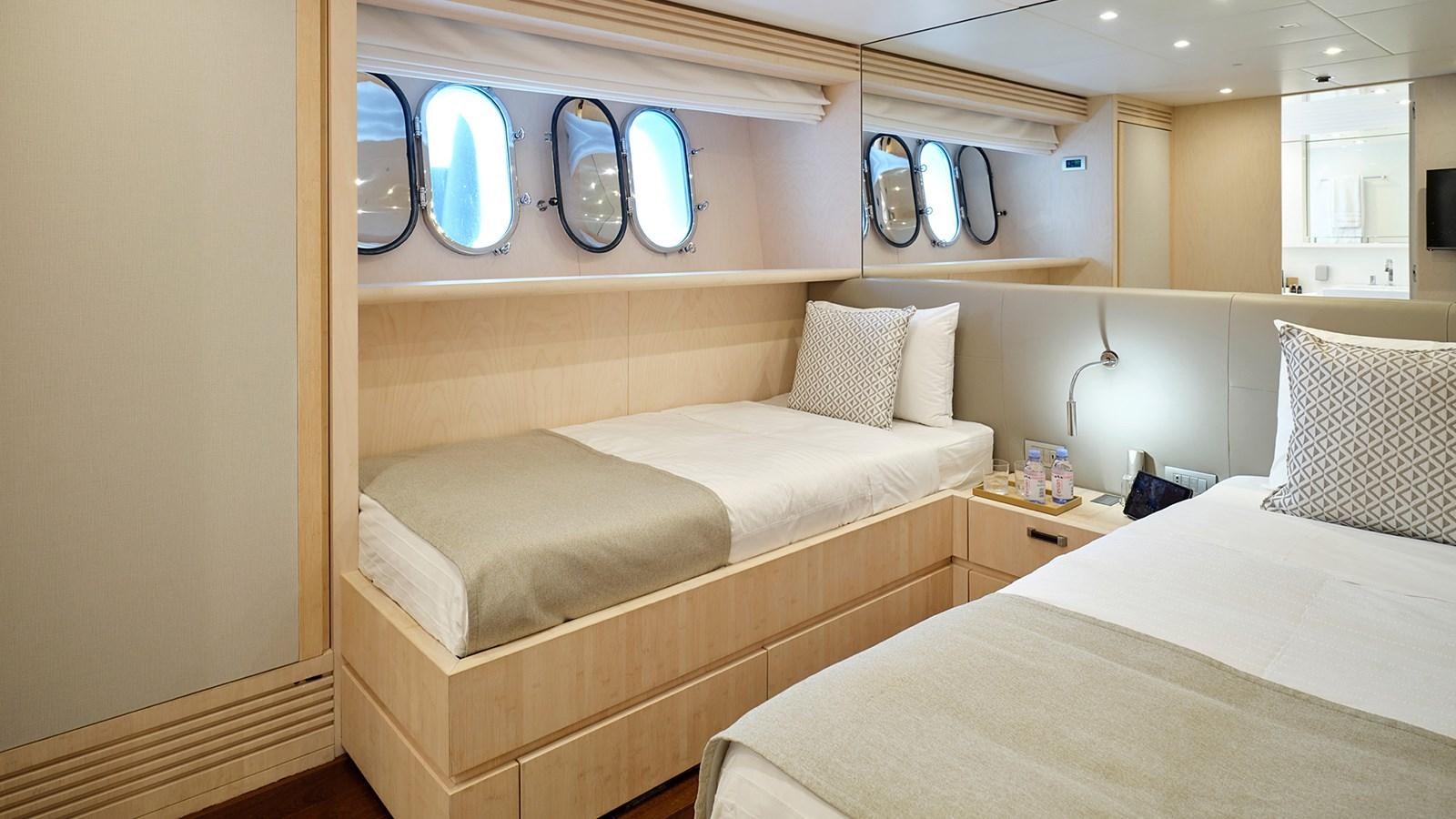 a room with beds and a mirror aboard WHITE KNIGHT Yacht for Sale