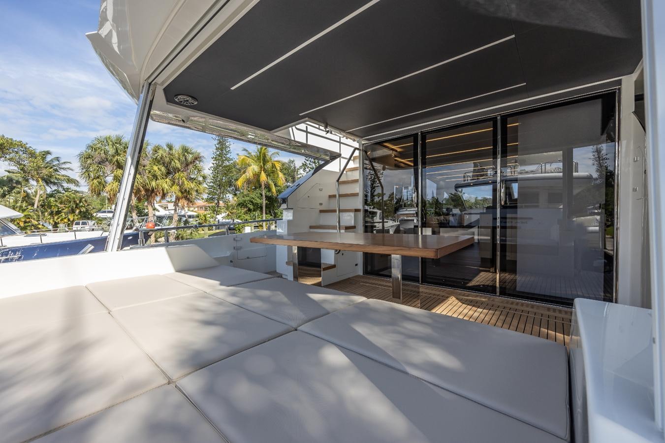 a room with a large glass door and a table with chairs and a view of the water and aboard 2024 ASTONDOA 66 FLYBRIDGE Yacht for Sale