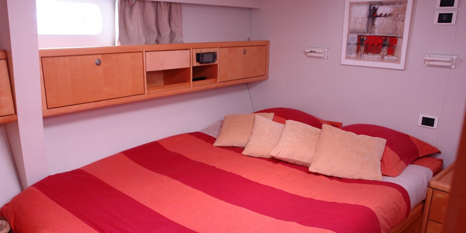 a bed with red sheets aboard DJANGO TOO Yacht for Sale