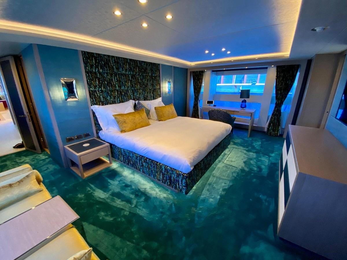 a bedroom with a bed and a desk aboard SKYE Yacht for Sale