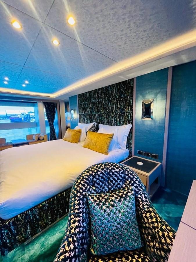 a bedroom with a bed and a window aboard SKYE Yacht for Sale
