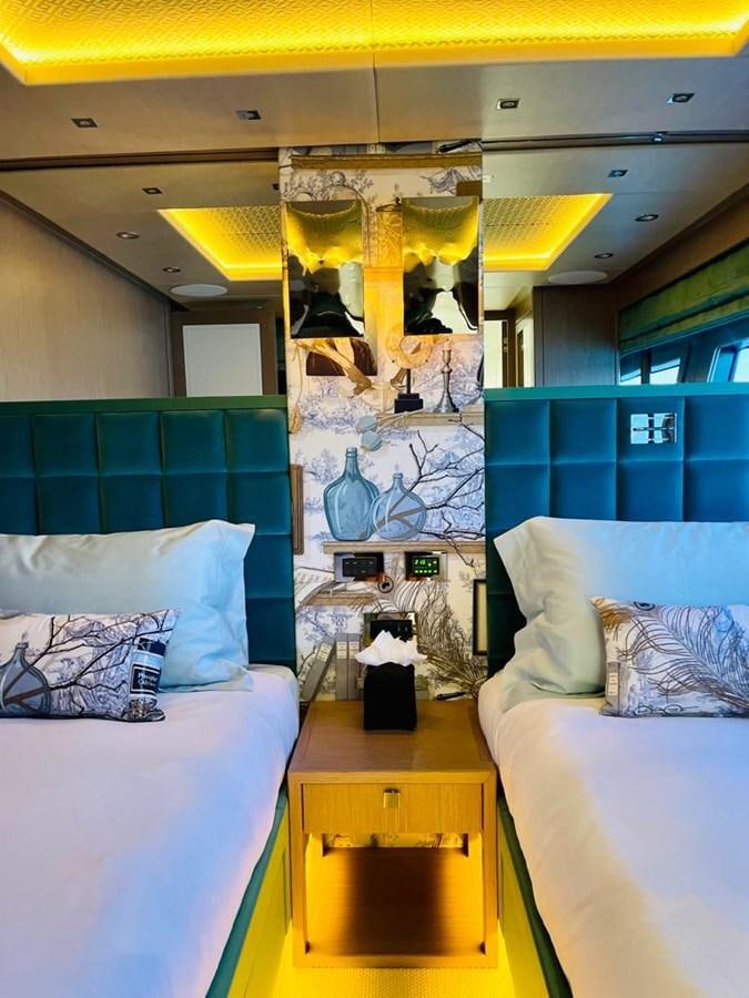 a bedroom with a bed and a desk aboard SKYE Yacht for Sale