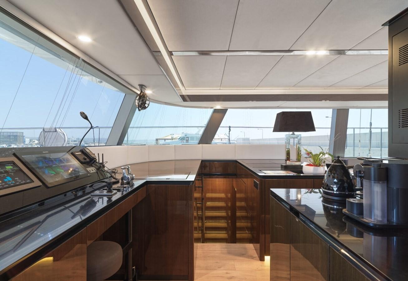 a kitchen with a large window aboard SUNREEF 70 SAIL - 2023 "OV Yacht for Sale