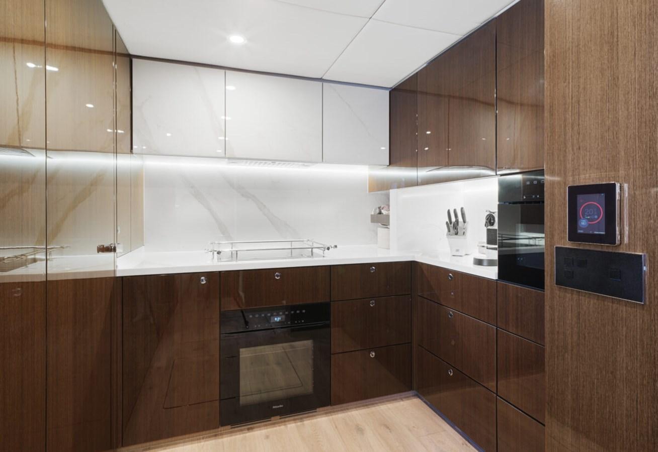 a kitchen with wooden cabinets aboard SUNREEF 70 SAIL - 2023 "OV Yacht for Sale