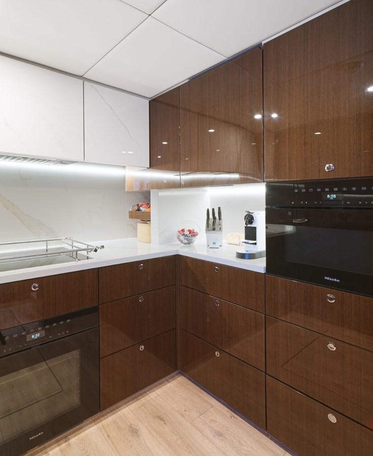 a kitchen with wooden cabinets aboard SUNREEF 70 SAIL - 2023 "OV Yacht for Sale