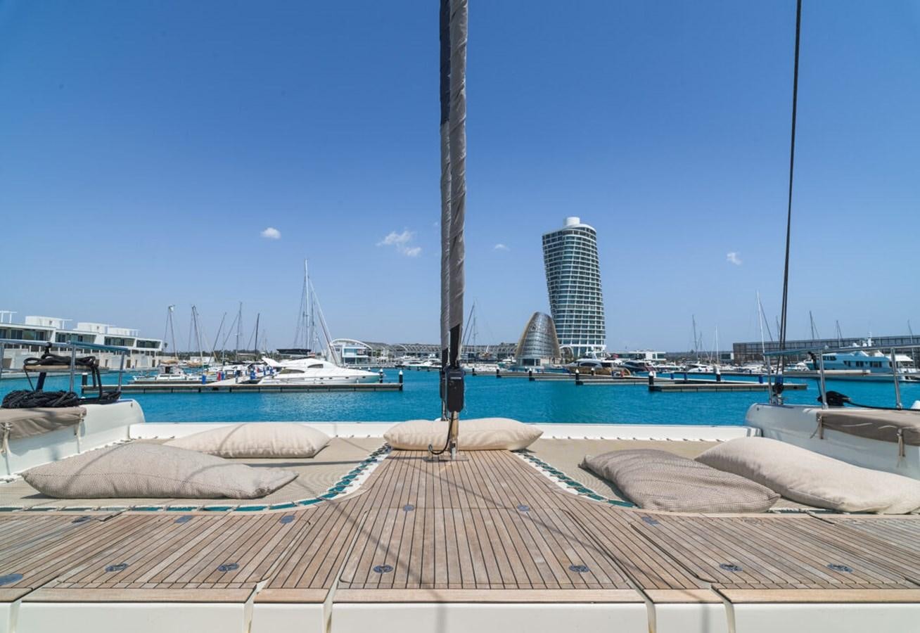 a dock with boats and buildings in the background aboard SUNREEF 70 SAIL - 2023 "OV Yacht for Sale