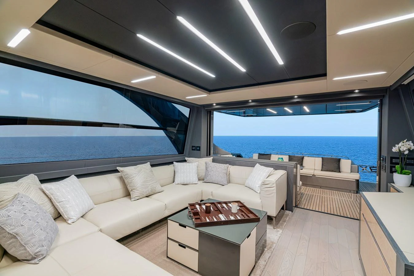 a room with a couch and a table with a window aboard SILVER BULLET Yacht for Sale