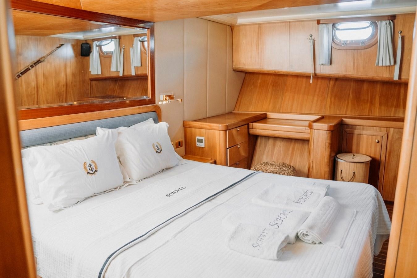 a bed with white sheets and pillows aboard CUSTOM MADE MOTORSAILER Yacht for Sale