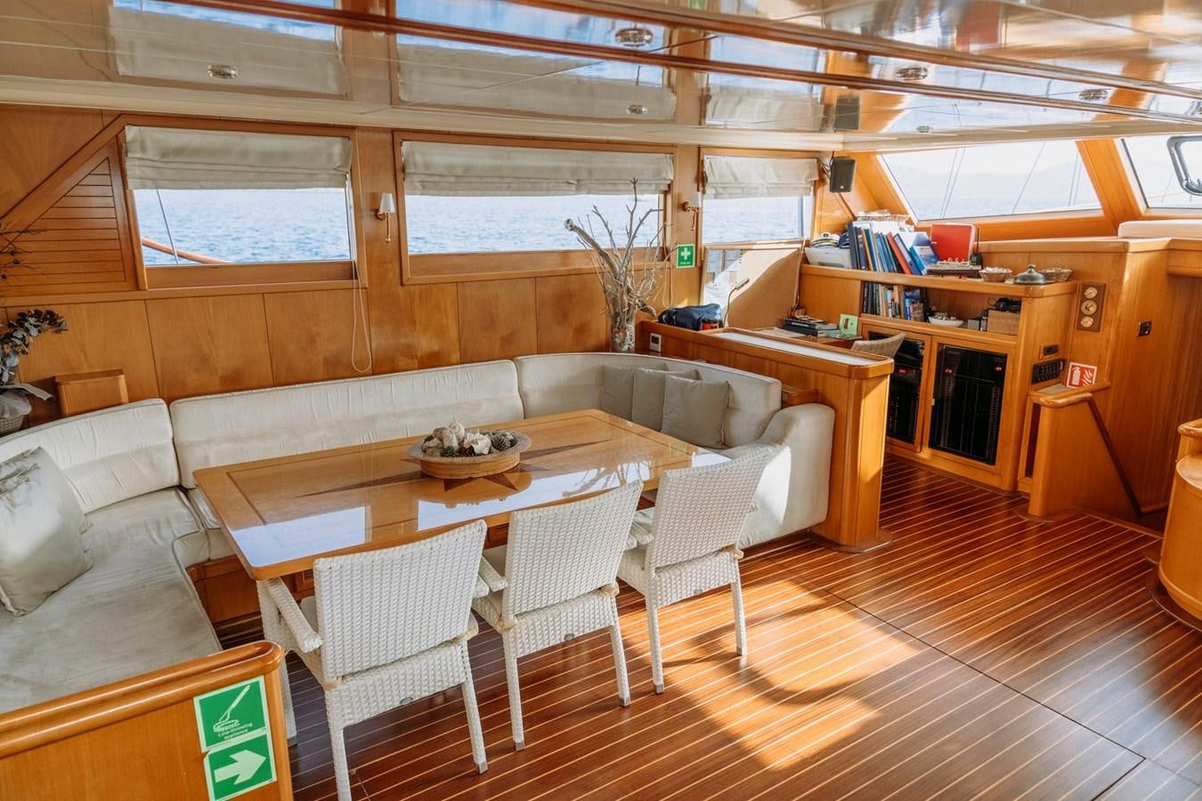 a room with a table chairs and a bench aboard CUSTOM MADE MOTORSAILER Yacht for Sale
