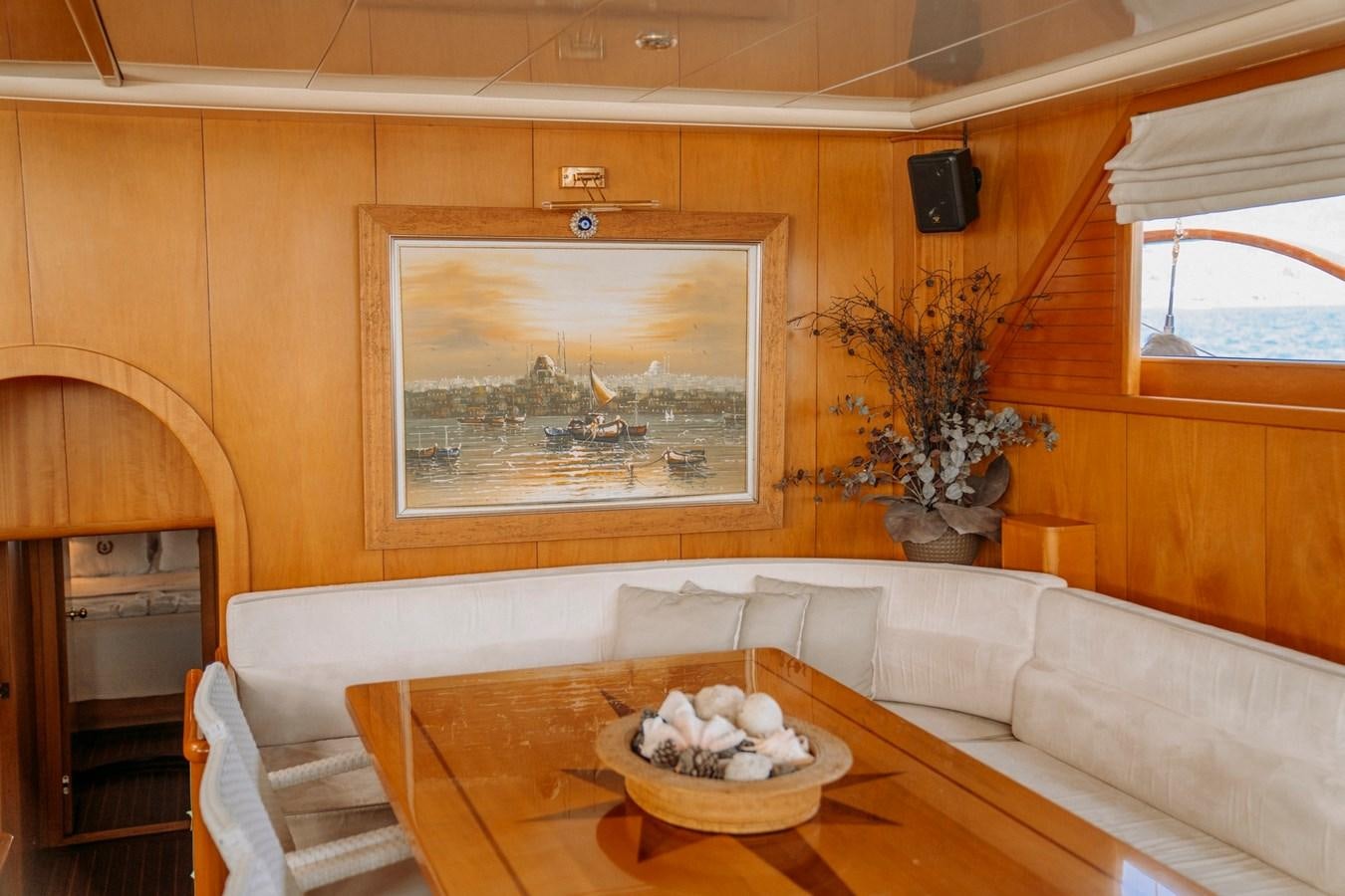 a living room with a table and couches aboard CUSTOM MADE MOTORSAILER Yacht for Sale