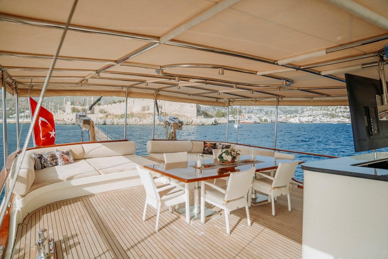 a boat with a table and chairs aboard CUSTOM MADE MOTORSAILER Yacht for Sale