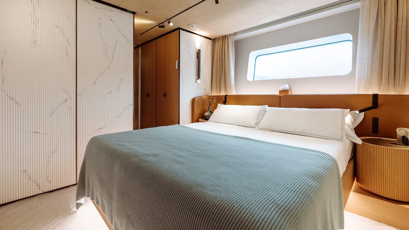 a bedroom with a bed and a window aboard SAL Yacht for Sale