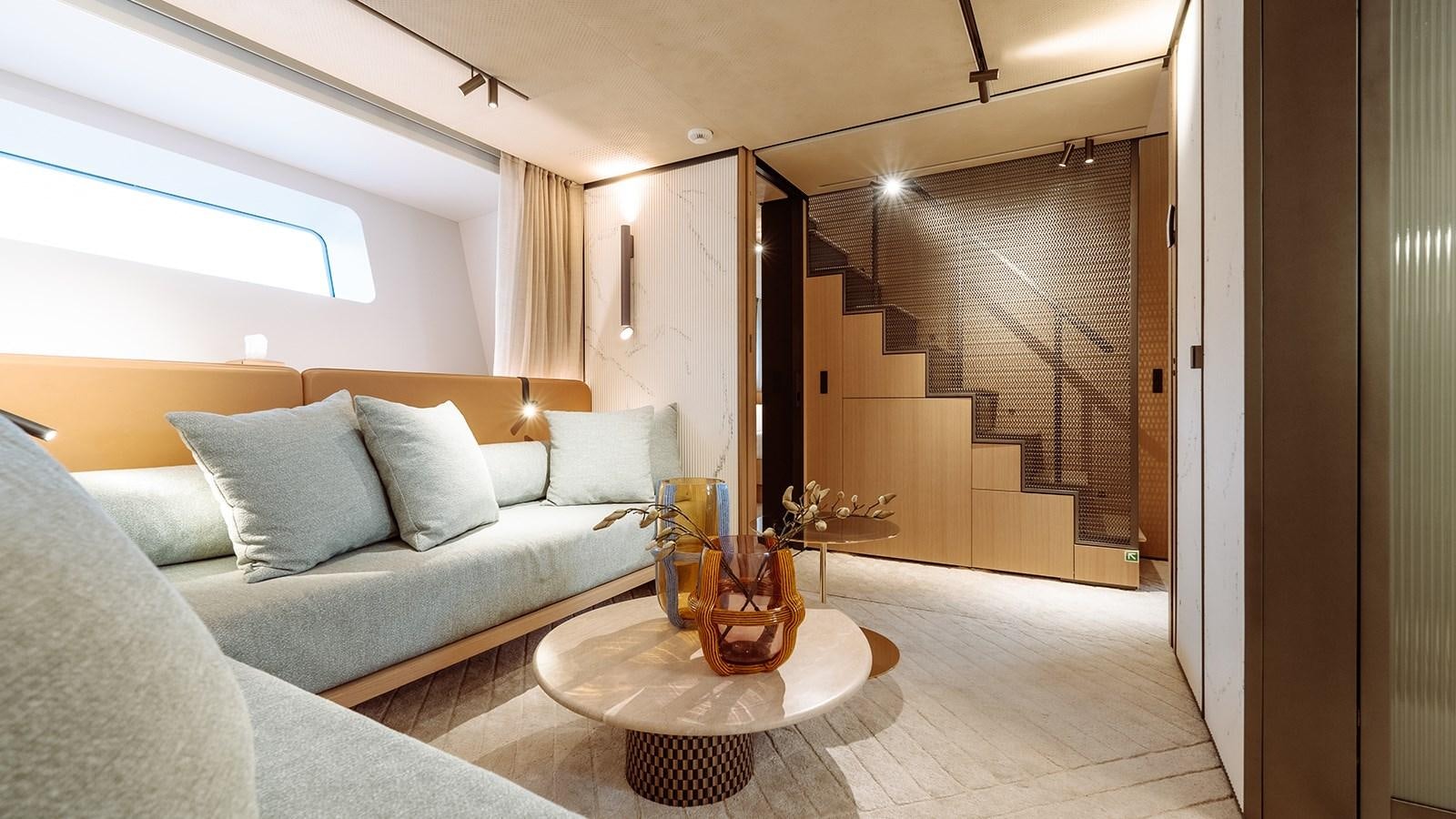 a living room with a glass coffee table and a glass door aboard SAL Yacht for Sale