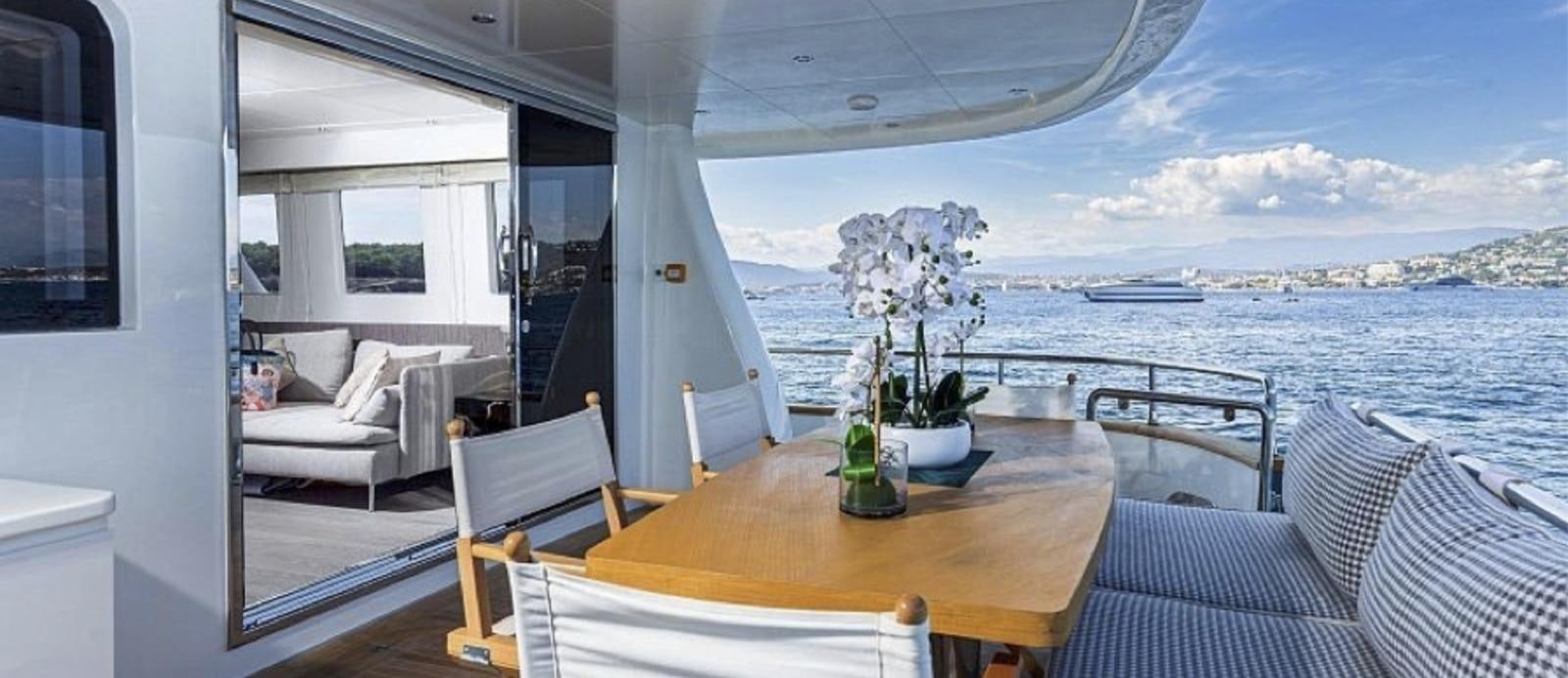 a table with chairs and a plant on it aboard T9 Yacht for Sale