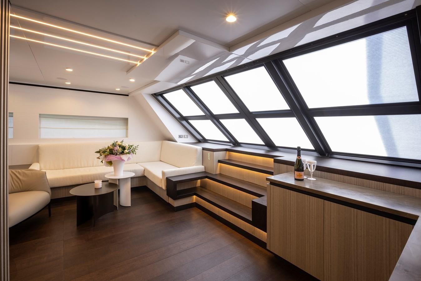 a room with a wood floor and a couch and a table with a glass window aboard S07 SPIDER Yacht for Sale