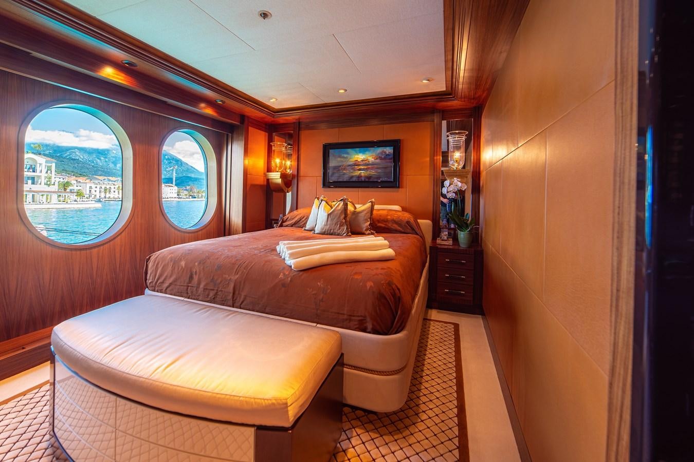 a bedroom with a bed and a window aboard TRIDENT Yacht for Sale