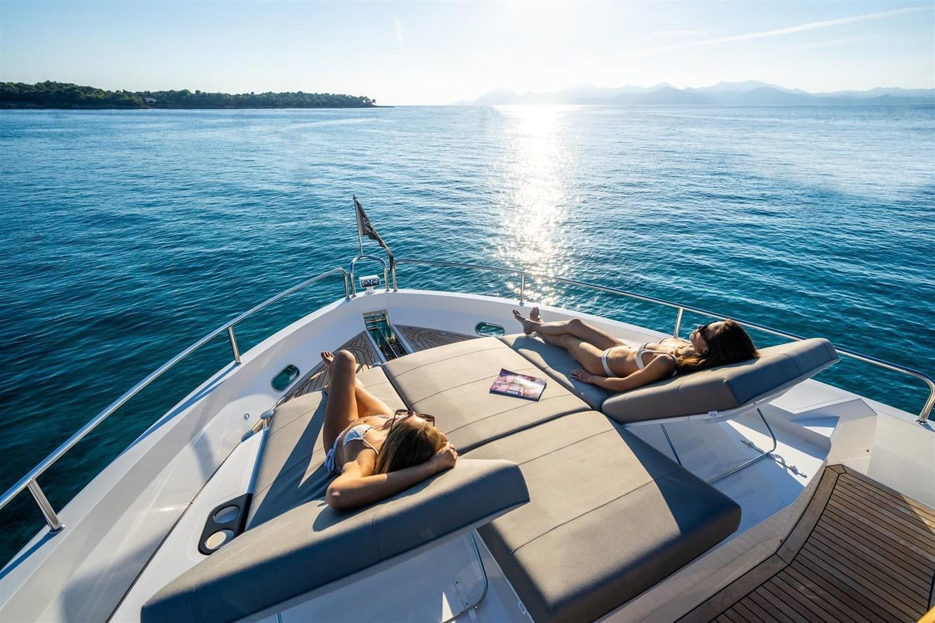 a man and woman lying on a boat in the water aboard SUNSEEKER 88 Yacht for Sale