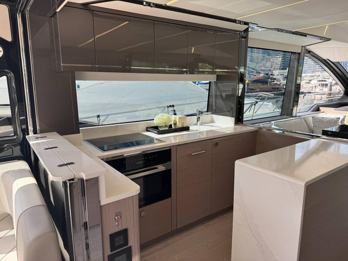 a kitchen with a large window aboard SUNSEEKER 65 SPORTS Yacht for Sale