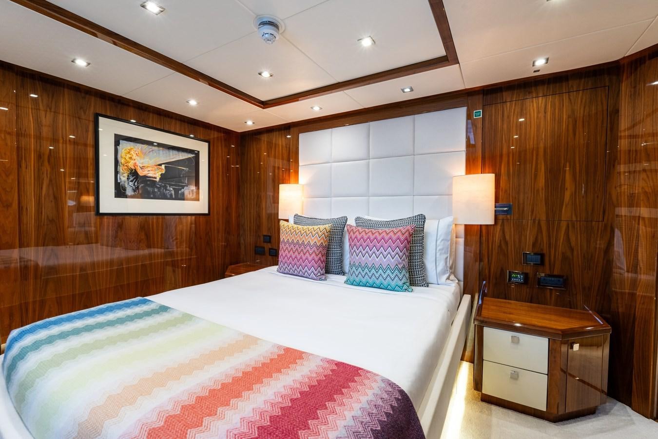 a bedroom with a bed and a dresser aboard ANYA Yacht for Sale