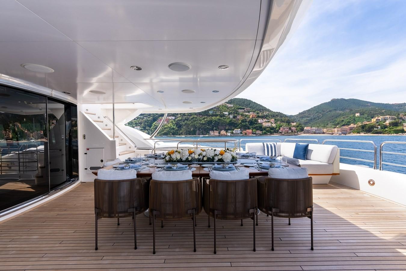a table and chairs on a deck overlooking a large body of water aboard ANYA Yacht for Sale