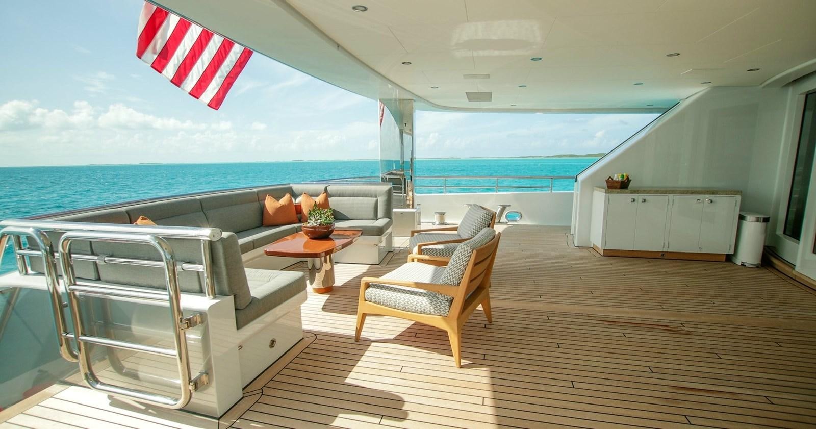 a large white lounge chair on a deck overlooking a large body of water aboard W Yacht for Sale