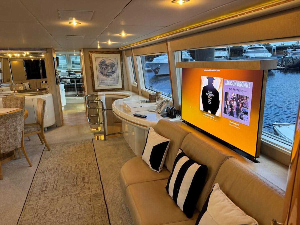 a room with a table chairs and a large screen on the wall aboard DARE TO DREAM Yacht for Sale